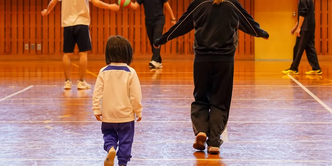 体育館で、大人と小さな子が遊ぶ