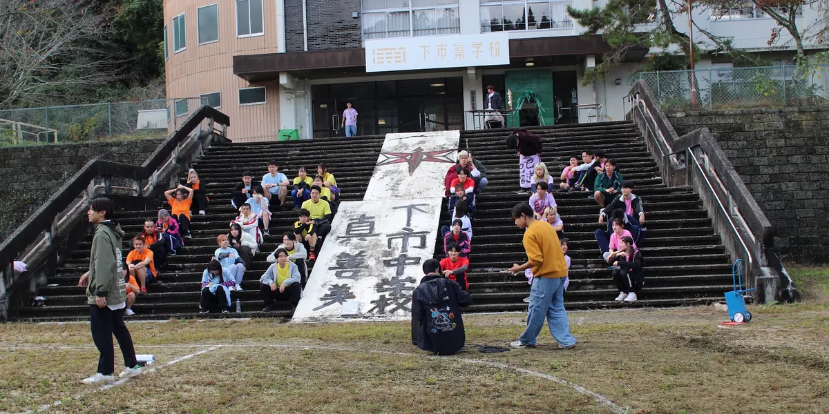 校舎の前の大階段に集まる人たち